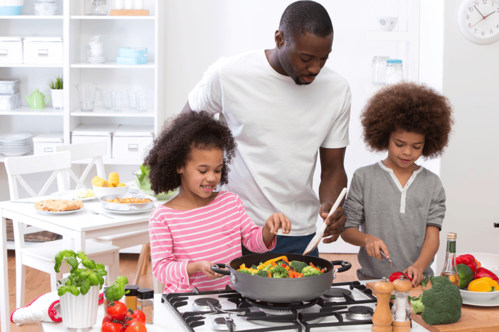 a father teaching his  two children how to cook and enjoy heart healthy food